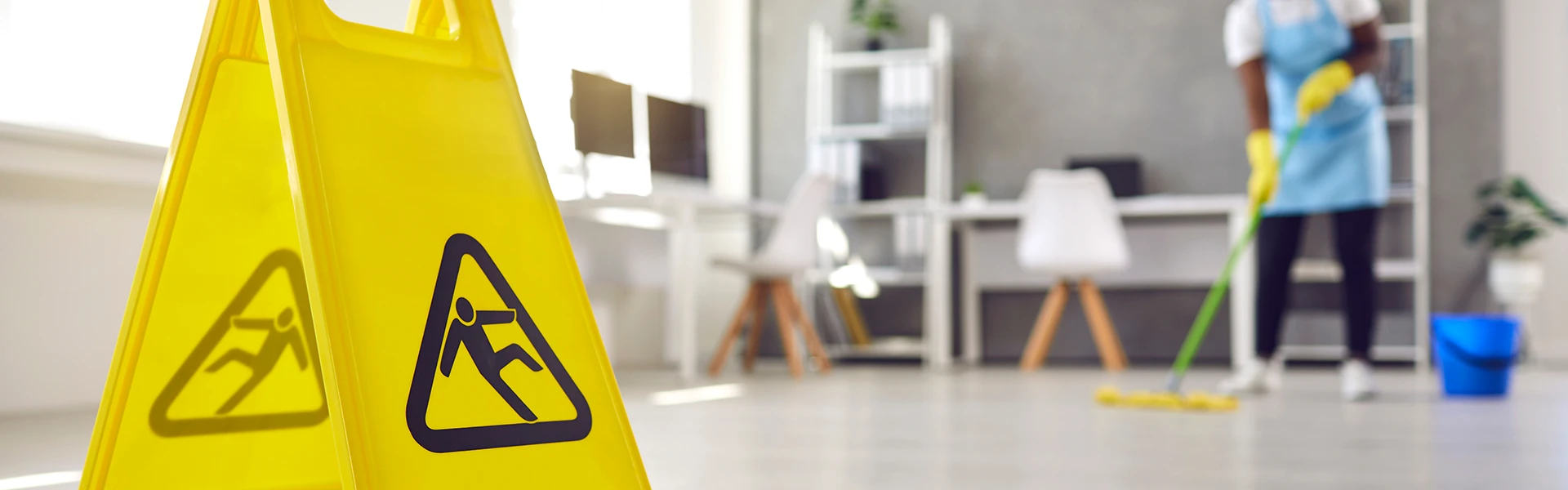 In einem Büro Nahaufnahme eines Plastikschildes mit einem Piktogramm einer Figur, die ausrutscht und hinfällt