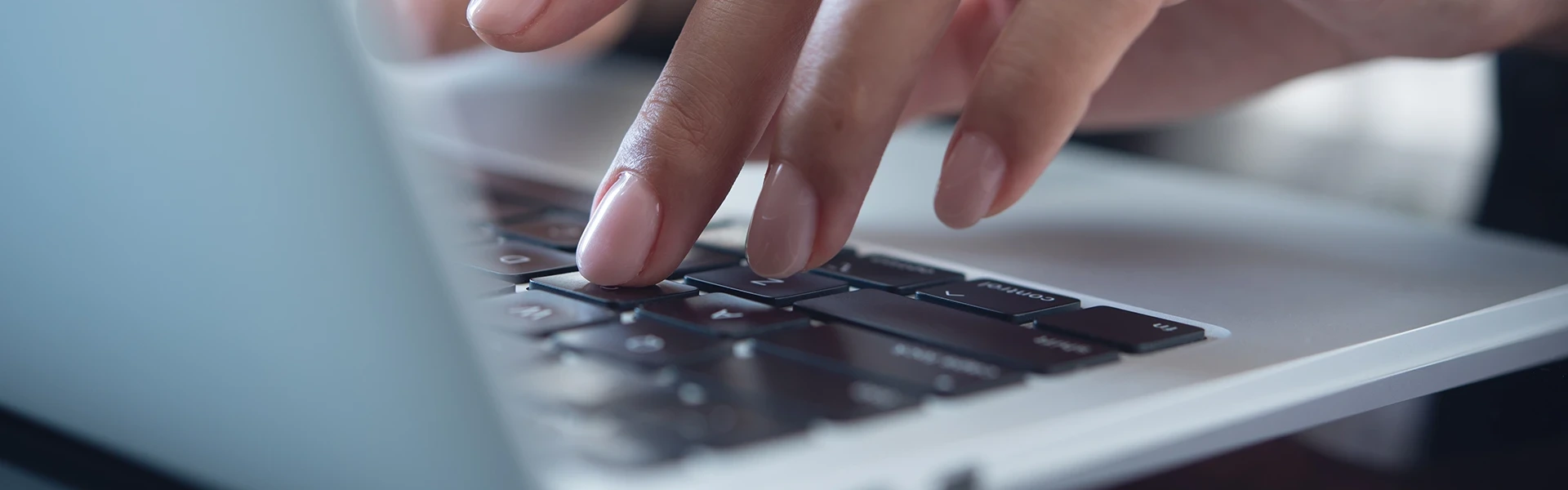 Nahaufnahme einer Geschäftsfrau, die mit der Hand auf der Tastatur eines Laptops eine Mail schreibt