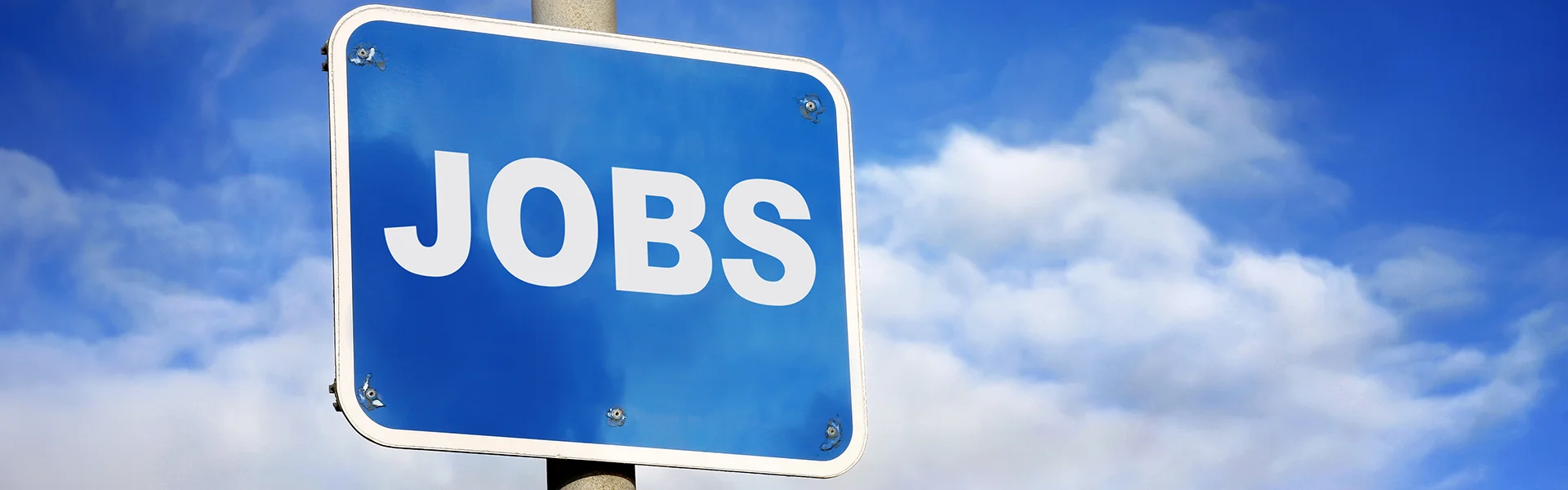 Ein blaues Schild mit der Aufschrift JOBS und im Hintergrund ein blauer Himmel
